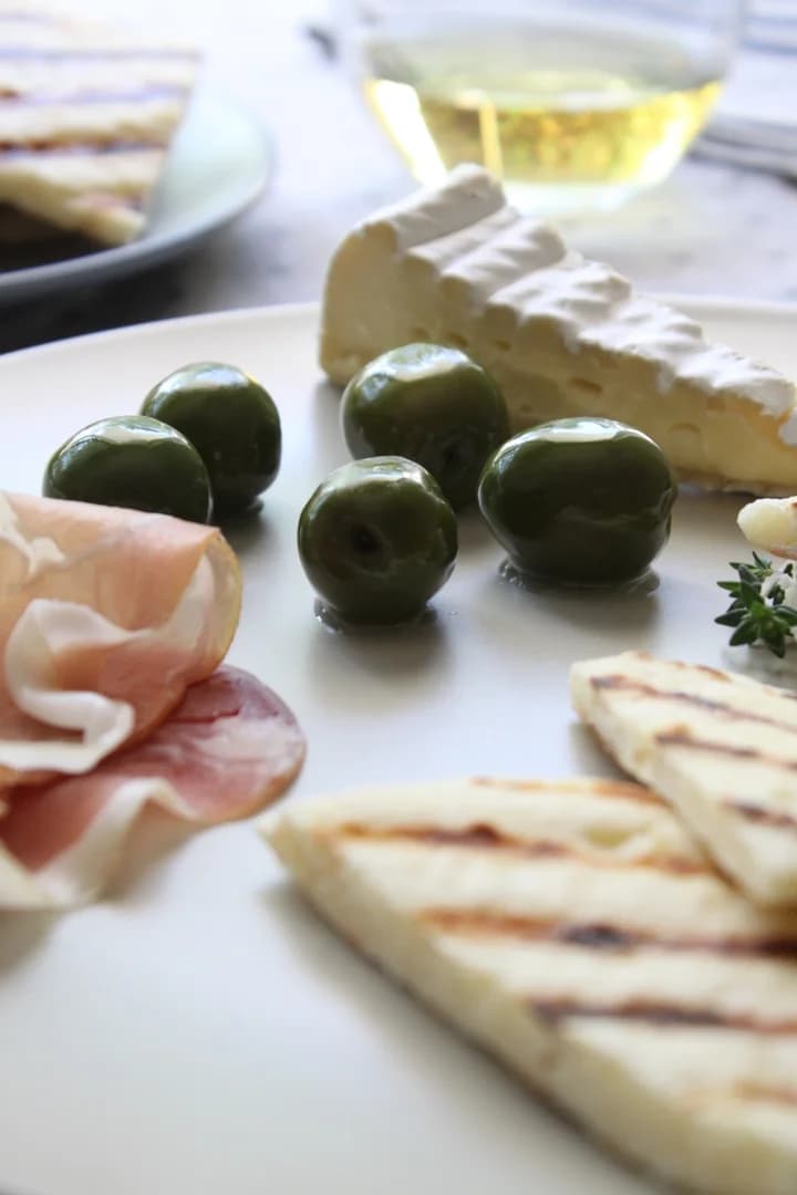 Flatbread z wędzonymi oliwkami, brie i prosciutto